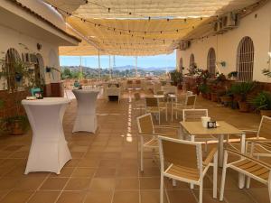 a restaurant with tables and chairs in a building at Hotel Meson Fuente del Pino in Olvera