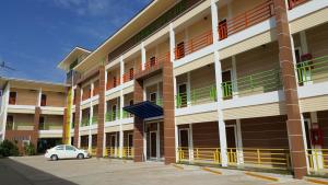 a car parked in front of a building at Charoensuk Grand Hotel in Kabin Buri