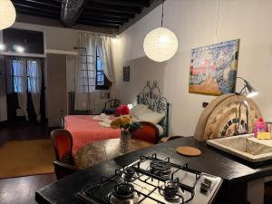 a kitchen with a stove and a living room with a bed at Assisi 2 by E-Roi Rent - Museo Egizio in Turin