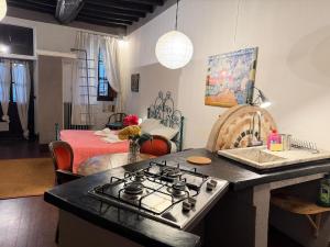 a kitchen with a stove top oven next to a living room at Assisi 2 by E-Roi Rent - Museo Egizio in Turin