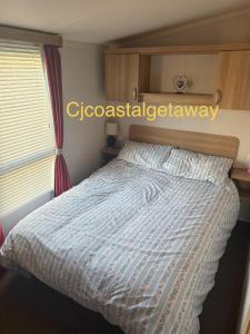 a bedroom with a bed with a blue and white comforter at CJ Coastal Getaway #2 in Rhyl