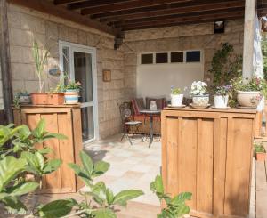 a patio with potted plants on top of wooden cabinets at Pinat Hashaked in Rosh Pinna