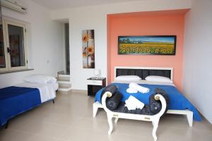 a bedroom with a bed and a chair and a painting at Belvedere di Ciro' in Cirò