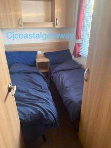 two beds in a small room with a window at CJ Coastal Getaway #2 in Rhyl