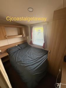 a small bed in a small room with a window at CJ Coastal Getaway #2 in Rhyl