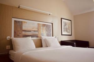 a hotel room with a large bed with white pillows at Résidence Château du Mée in Le Mée-sur-Seine