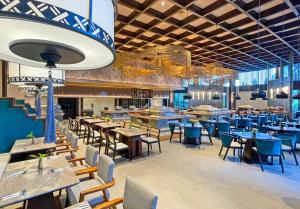 a restaurant with wooden tables and chairs and a cafeteria at The Singhasari Resort Batu in Batu