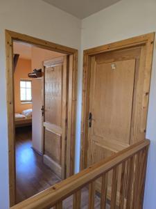 a hallway with a wooden door and a staircase at Pod modříny in Adršpach