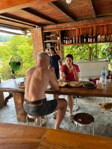 a man and a woman sitting at a table eating food at ANOR - Farmstay - Double bed in Ha Tia