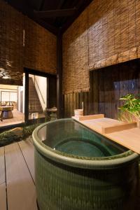 una grande vasca da bagno verde in una stanza di Kyotoya Tsuki no Yu Bettei a Kyoto