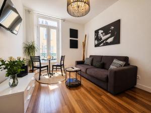 a living room with a couch and a table at Suite Notre Dame - Appartements in Cannes
