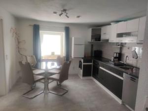 a kitchen with a table and chairs in a room at NEU! Ferienwohnung am Ahlberg in Toppenstedt