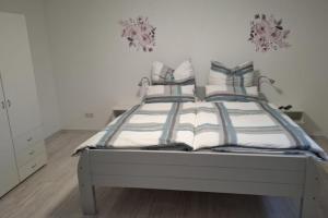 a bedroom with a bed with striped sheets and pillows at NEU! Ferienwohnung am Ahlberg in Toppenstedt