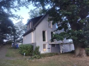 a white house with a tree in front of it at NEU! Ferienwohnung am Ahlberg in Toppenstedt