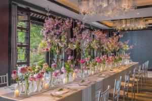 a long table with many vases filled with flowers at Four Seasons Hotel Hangzhou at West Lake in Hangzhou +114 photos