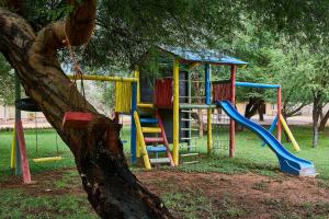 a playground with a slide and a tree at Hammerstein Lodge in Hammerstein
