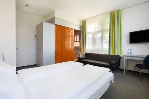 a hotel room with a bed and a couch at Hotel & Gasthaus Die Perle in Perlen +14 photos