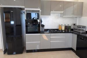 a kitchen with white cabinets and a black refrigerator at Villa Bonheur - Piscine sans vis-à-vis in Berkane +24 photos