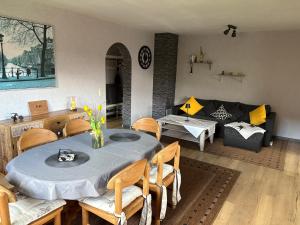 a living room with a table and chairs and a couch at Ferienwohnung Klara in Hilchenbach