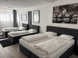 Ein Zimmer mit drei Betten und Bildern an der Wand in der Unterkunft LIVINN Tremonia Group - Dortmund Centrum in Dortmund