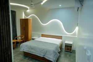 a bedroom with a bed with a white headboard at Arthanaa Villa in Mysore +6 photos