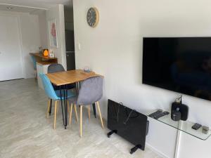 a dining room with a table and a tv on a wall at 2 Bedroom Unit in Howick in Auckland