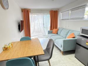 a living room with a blue couch and a table at 2 Bedroom Unit in Howick in Auckland