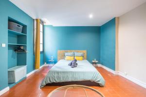 a blue bedroom with a bed with a teddy bear on it at L’Escapade Nîmoise - grand studio centre Nîmes in Nîmes