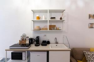 a kitchen counter with a sink and a microwave at Idumea Rooms in Lecce +12 photos