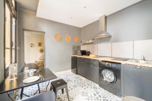 a kitchen with a washing machine and a table and chairs at L’Escapade Nîmoise - grand studio centre Nîmes in Nîmes +4 photos