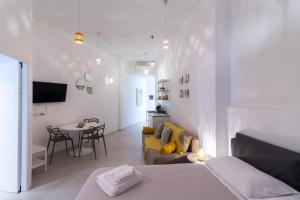 a room with a bed and a couch and a table at Idumea Rooms in Lecce