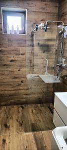 a bathroom with a glass shower with a sink at Múzsa Apartman in Siófok