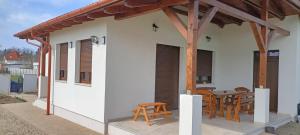 a small white house with a wooden roof at Múzsa Apartman in Siófok