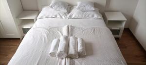 a bed with white blankets and white socks on it at Múzsa Apartman in Siófok