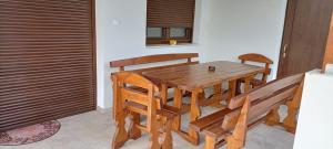 a wooden table and chairs in a room at Múzsa Apartman in Siófok