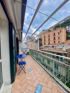 a balcony with a blue chair and a table on a building at FRANCESCA'S HOUSE in Minori