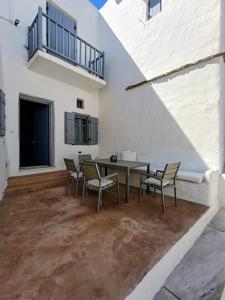 a patio with a table and chairs and a balcony at Amelie Villa with pool and amazing sea views, Paros in Márpissa