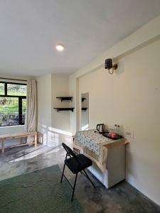 a room with a table and a chair in it at Soma House Dharamkot in McLeod Ganj