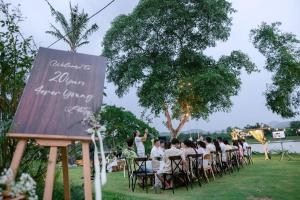a group of people sitting in chairs at a table at Vả Riverside Retreat in Hue +58 photos