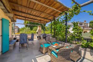 an outdoor patio with wicker furniture and a pergola at Rustikalna kuća za odmor VILLA MARE in Kornić