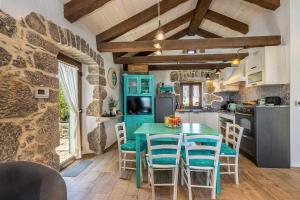 a kitchen with a table and chairs in a room at Rustikalna kuća za odmor VILLA MARE in Kornić