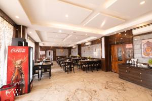 a restaurant with tables and chairs and a coke machine at Rath Inns Beach Resort Mandarmani in Mandarmoni