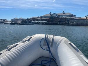 a boat in the water next to a building at Mandurah Houseboat Just Chillin in Mandurah