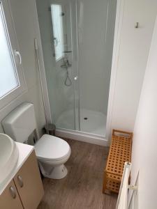 a white bathroom with a shower and a toilet at Løgballe Camping & Cottages in Stouby