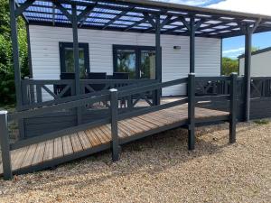 a house with a wooden deck and a pergola at Løgballe Camping & Cottages in Stouby +45 photos