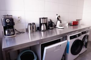 a kitchen with a counter top with a washing machine at Le Pays des Sources in Waimes