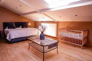 a bedroom with a bed and a baby crib at Le Pays des Sources in Waimes +33 photos