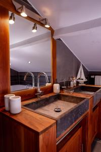 a kitchen with a sink and a large mirror at Le Pays des Sources in Waimes