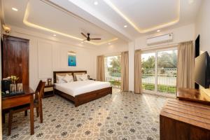 a bedroom with a bed and a desk and a television at Yellowstone Resort Arambol in Arambol
