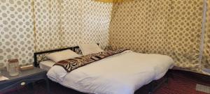 a bedroom with a bed in a room with wallpaper at Jispa Journey Camp Lahoul & Spiti in Manāli